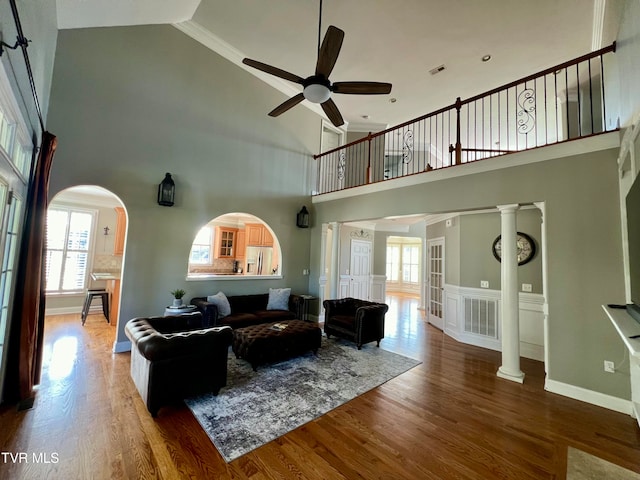 living room with hardwood / wood-style floors, ceiling fan, high vaulted ceiling, and plenty of natural light