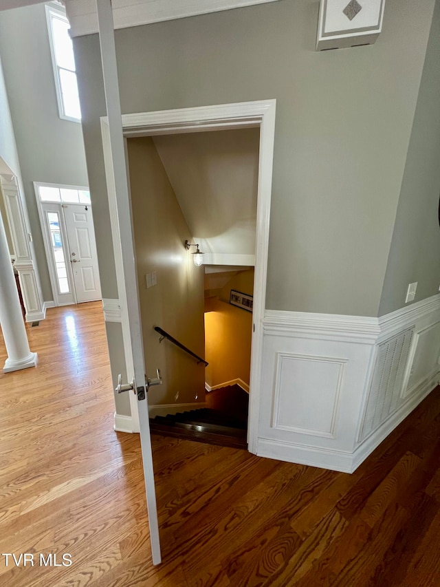 corridor featuring light hardwood / wood-style flooring and ornate columns