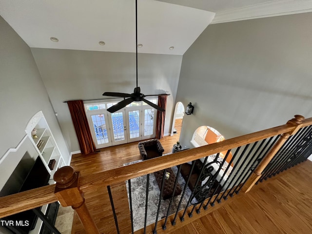 staircase with lofted ceiling, hardwood / wood-style floors, ornamental molding, and ceiling fan