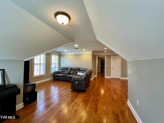 living room with lofted ceiling, ornamental molding, and wood-type flooring