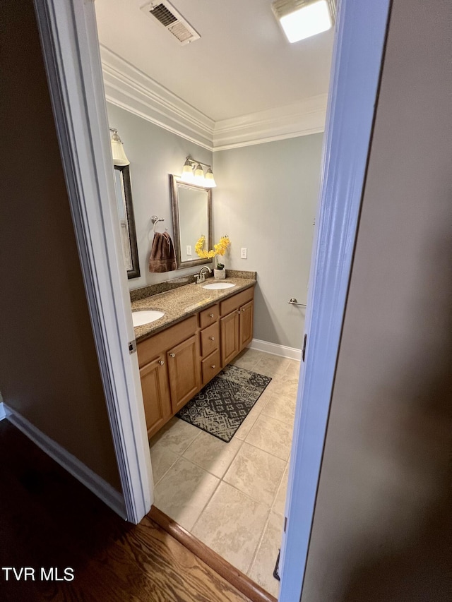 bathroom with vanity, ornamental molding, and tile patterned flooring