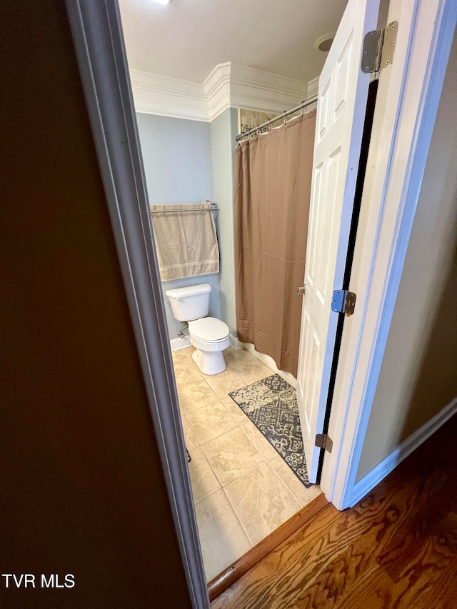 bathroom featuring hardwood / wood-style flooring, toilet, crown molding, and a shower with curtain