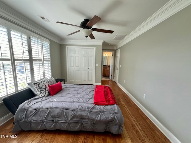 bedroom with a closet, hardwood / wood-style flooring, crown molding, and ceiling fan