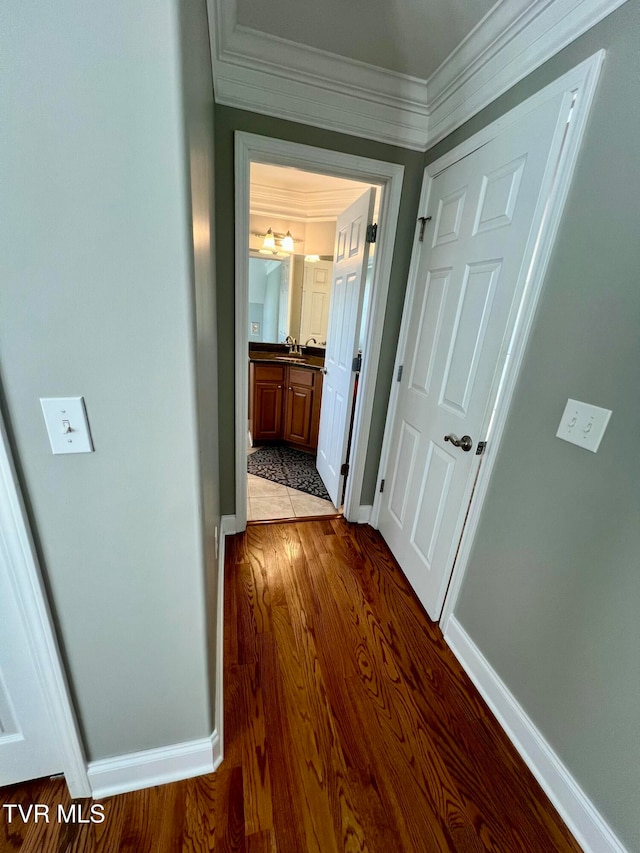 corridor featuring light hardwood / wood-style flooring, ornamental molding, and sink