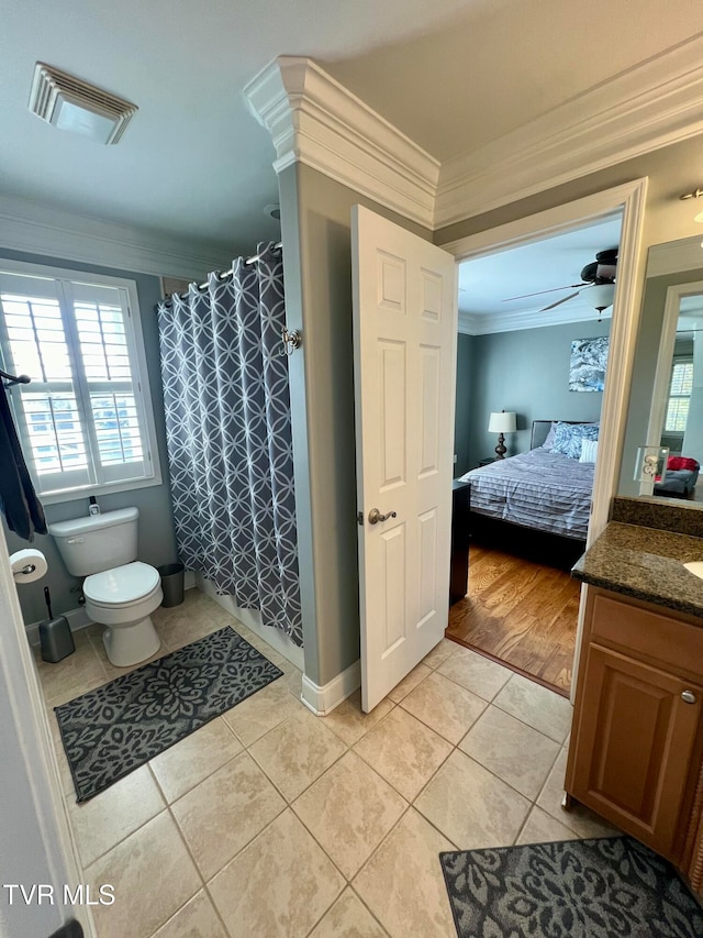 bathroom featuring toilet, ceiling fan, vanity, hardwood / wood-style flooring, and ornamental molding