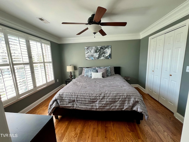 bedroom featuring a closet, hardwood / wood-style floors, crown molding, and ceiling fan