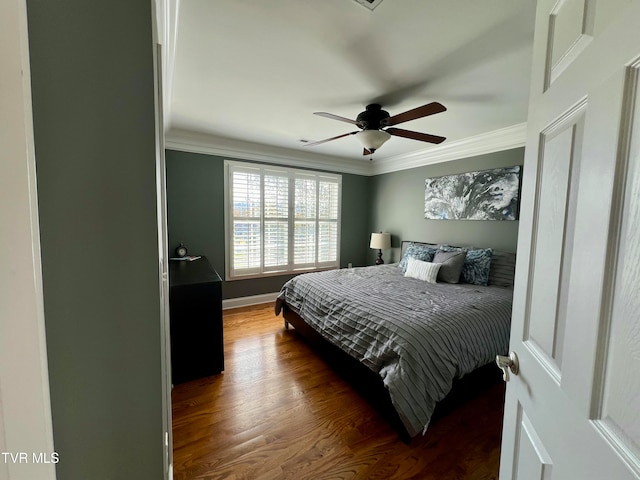 bedroom with dark wood-type flooring, crown molding, and ceiling fan