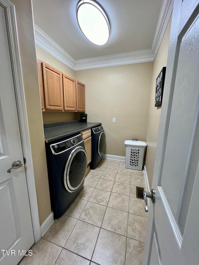 clothes washing area with crown molding, cabinets, and light tile patterned floors