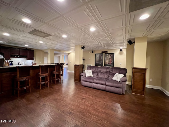 living room with indoor bar and dark wood-type flooring