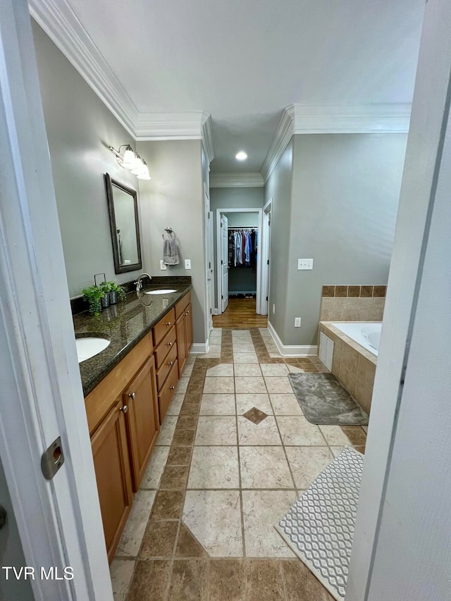 bathroom featuring vanity, tiled bath, and ornamental molding