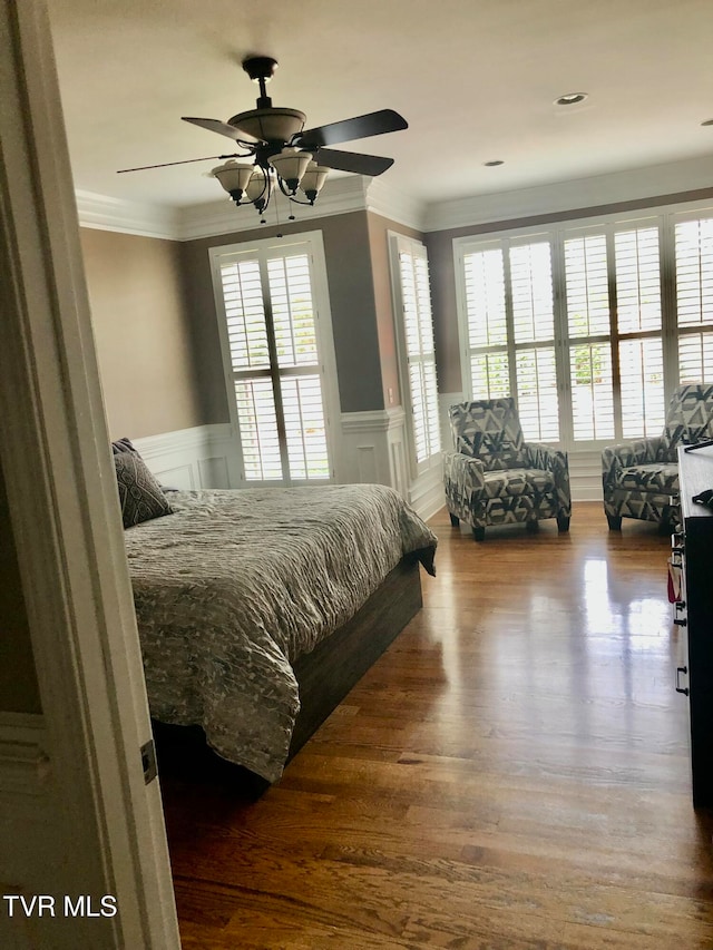 bedroom featuring ceiling fan, crown molding, and wood-type flooring