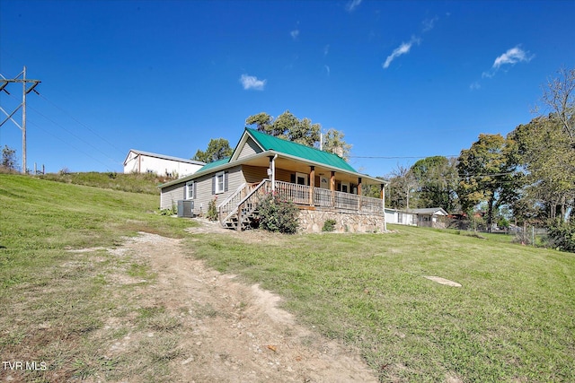 back of property featuring a yard, central air condition unit, and covered porch