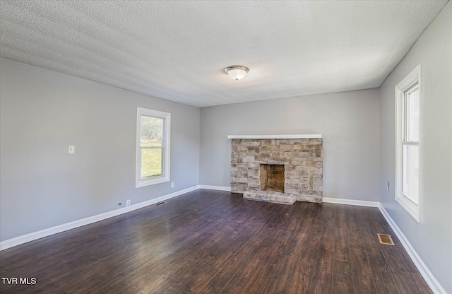 unfurnished living room with a textured ceiling and dark hardwood / wood-style flooring