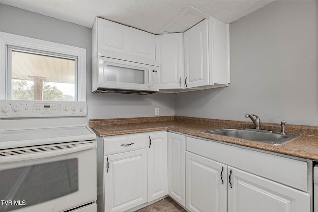 kitchen featuring white appliances, sink, a textured ceiling, and white cabinetry