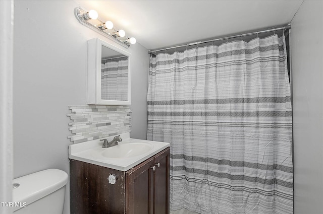 bathroom with toilet, vanity, a shower with shower curtain, and tasteful backsplash