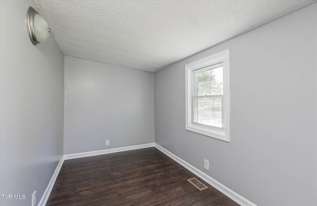 unfurnished room featuring dark hardwood / wood-style floors and a textured ceiling