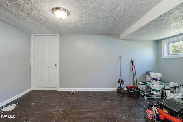 basement with a textured ceiling and dark wood-type flooring