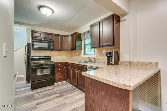 120 Rock Rd, Bristol, TN 37620 - kitchen featuring black appliances, a sink, a peninsula, light countertops, and light wood-style floors