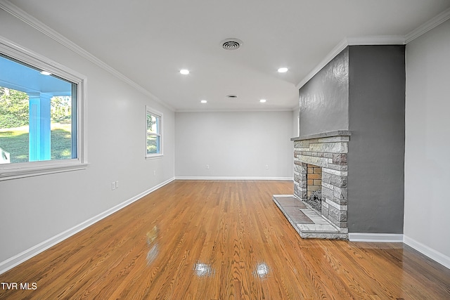 unfurnished living room featuring ornamental molding, light wood-type flooring, and a fireplace