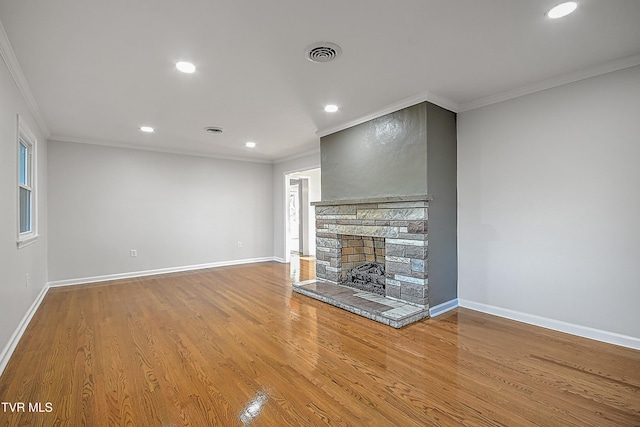 unfurnished living room with wood-type flooring, a fireplace, and ornamental molding