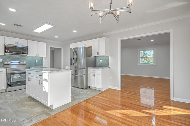 kitchen featuring backsplash, light hardwood / wood-style flooring, stainless steel appliances, hanging light fixtures, and white cabinets