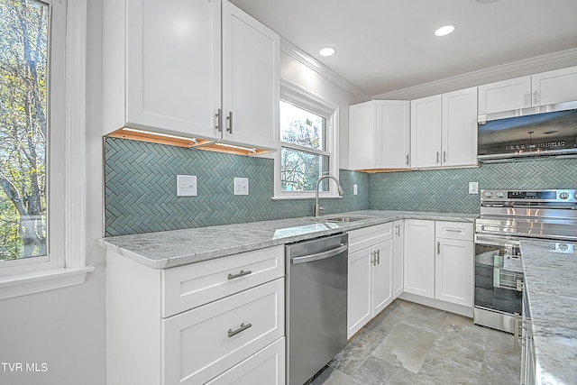 kitchen with ornamental molding, white cabinets, appliances with stainless steel finishes, and sink