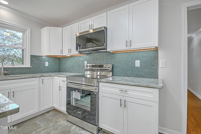 kitchen with sink, backsplash, white cabinetry, appliances with stainless steel finishes, and light stone countertops