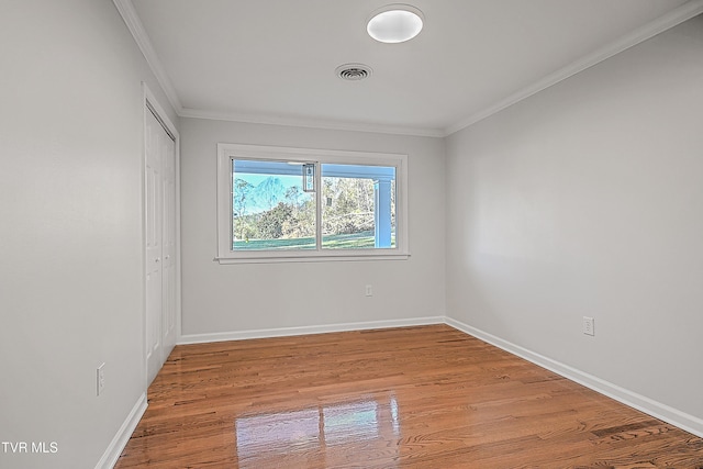 empty room featuring crown molding and light wood-type flooring