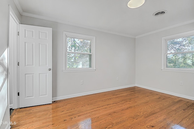 empty room with light wood-type flooring and crown molding