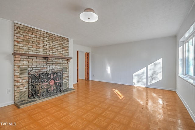 unfurnished living room with a textured ceiling, a fireplace, and light parquet floors