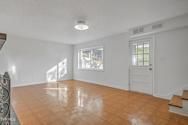 entryway featuring a wealth of natural light, light parquet flooring, and a textured ceiling