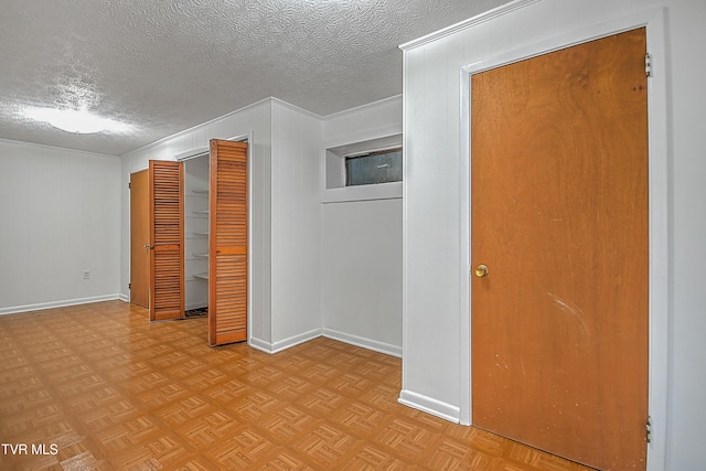 interior space with ornamental molding, light parquet flooring, and a textured ceiling