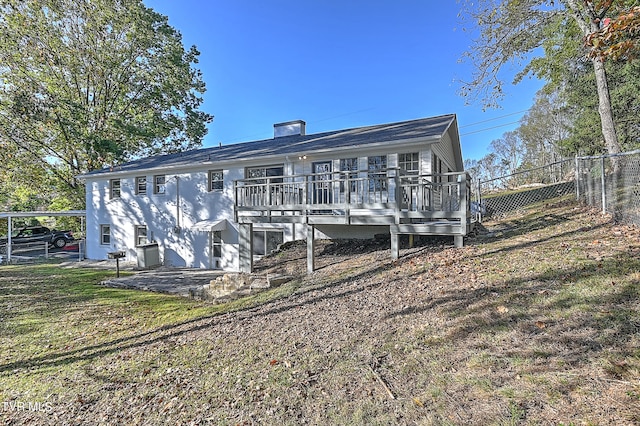 back of house with cooling unit, a deck, a patio, and a lawn