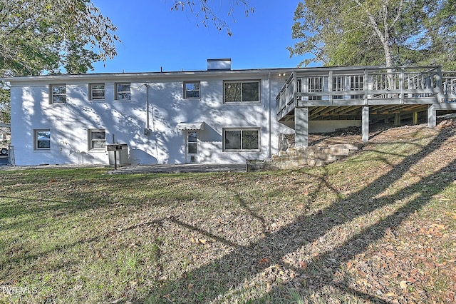 rear view of property featuring a yard and a wooden deck