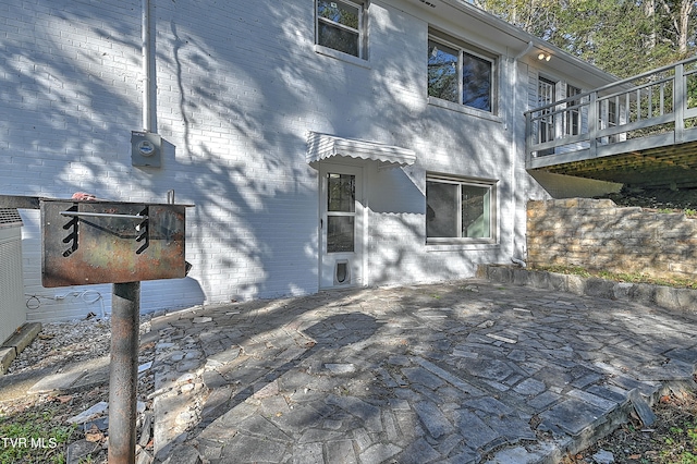 view of home's exterior featuring a patio and a wooden deck