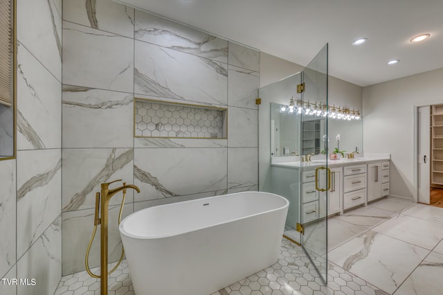 bathroom featuring a bath, vanity, and tile walls