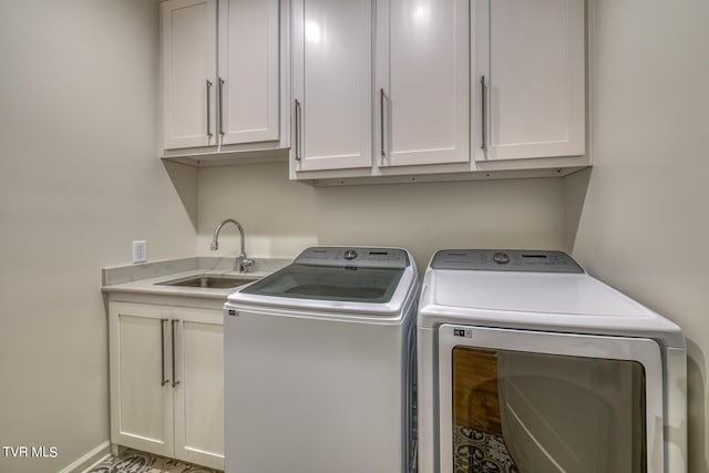 laundry room with washer and clothes dryer, sink, and cabinets