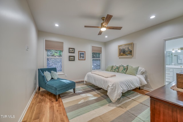 bedroom featuring ceiling fan, light hardwood / wood-style flooring, and ensuite bath