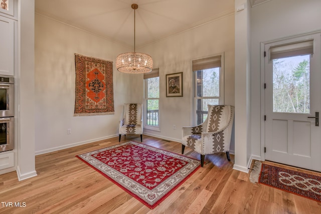 sitting room with plenty of natural light, light hardwood / wood-style floors, and crown molding