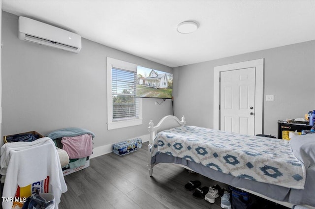 bedroom with an AC wall unit and wood-type flooring