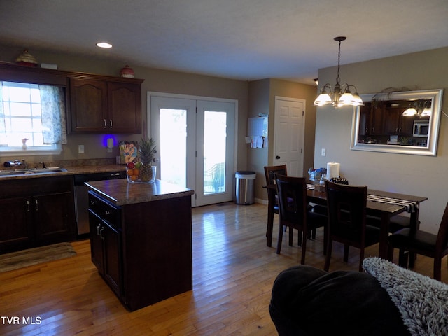 kitchen featuring dark brown cabinetry, sink, light hardwood / wood-style flooring, a center island, and a notable chandelier