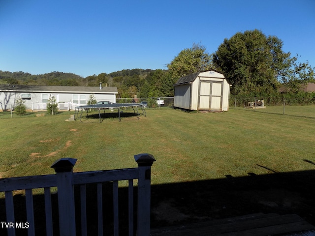 view of yard featuring a storage unit and a trampoline