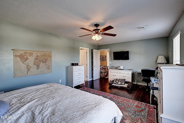 bedroom with ceiling fan, a textured ceiling, and dark hardwood / wood-style flooring