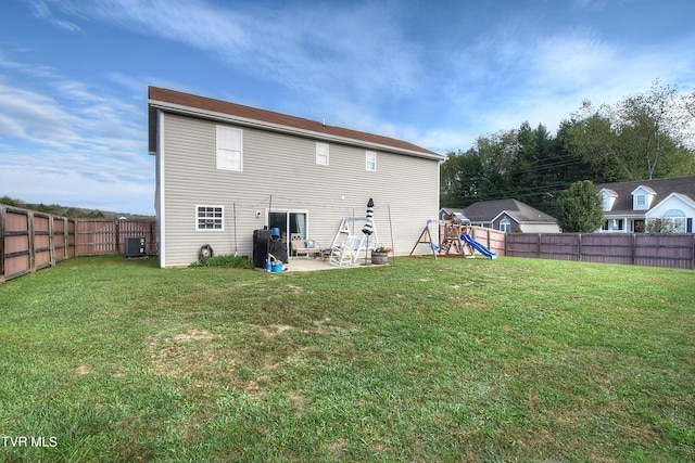 rear view of house featuring a lawn, a patio, and central AC