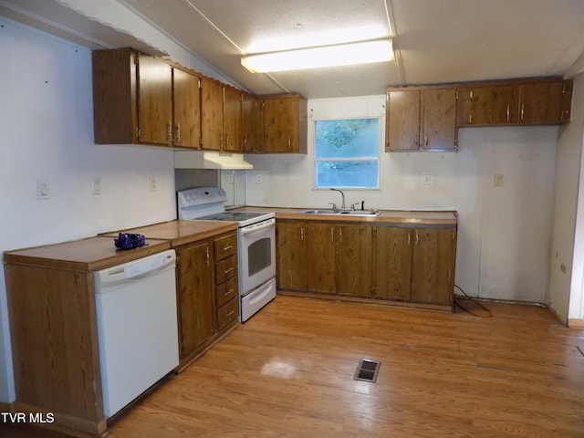 kitchen with light hardwood / wood-style flooring, white appliances, and sink