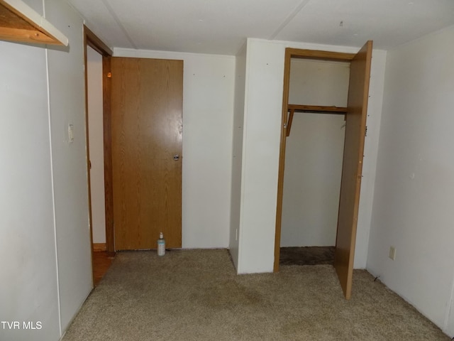 unfurnished bedroom with light carpet and a closet