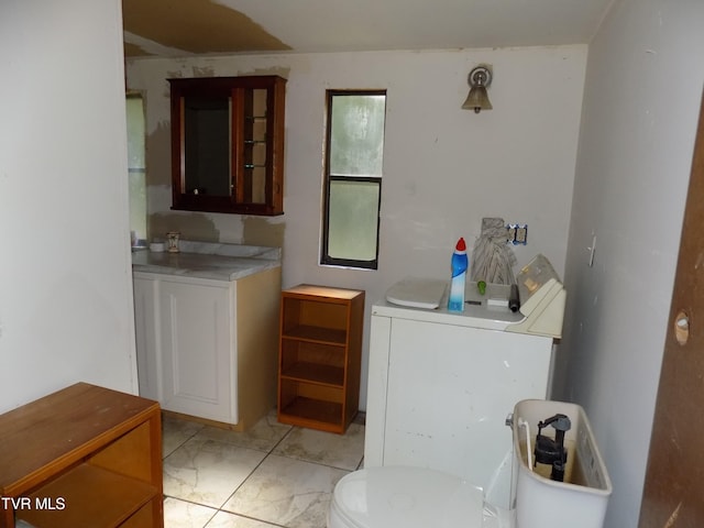 bathroom with washing machine and clothes dryer and toilet