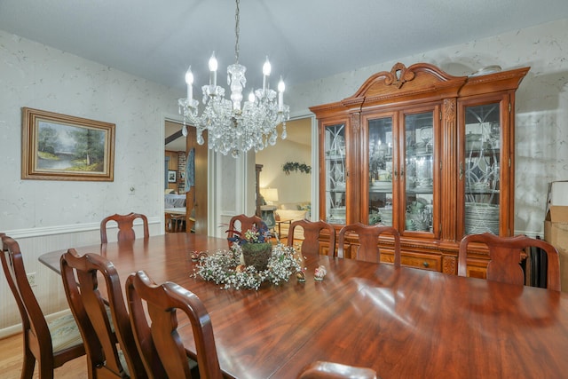 dining space with light hardwood / wood-style flooring and a chandelier