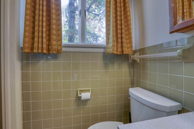 bathroom with tile walls and toilet