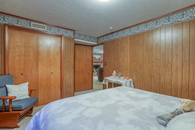 bedroom with crown molding, carpet flooring, and a textured ceiling